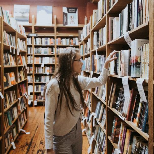 Ung kvinde på bibliotek